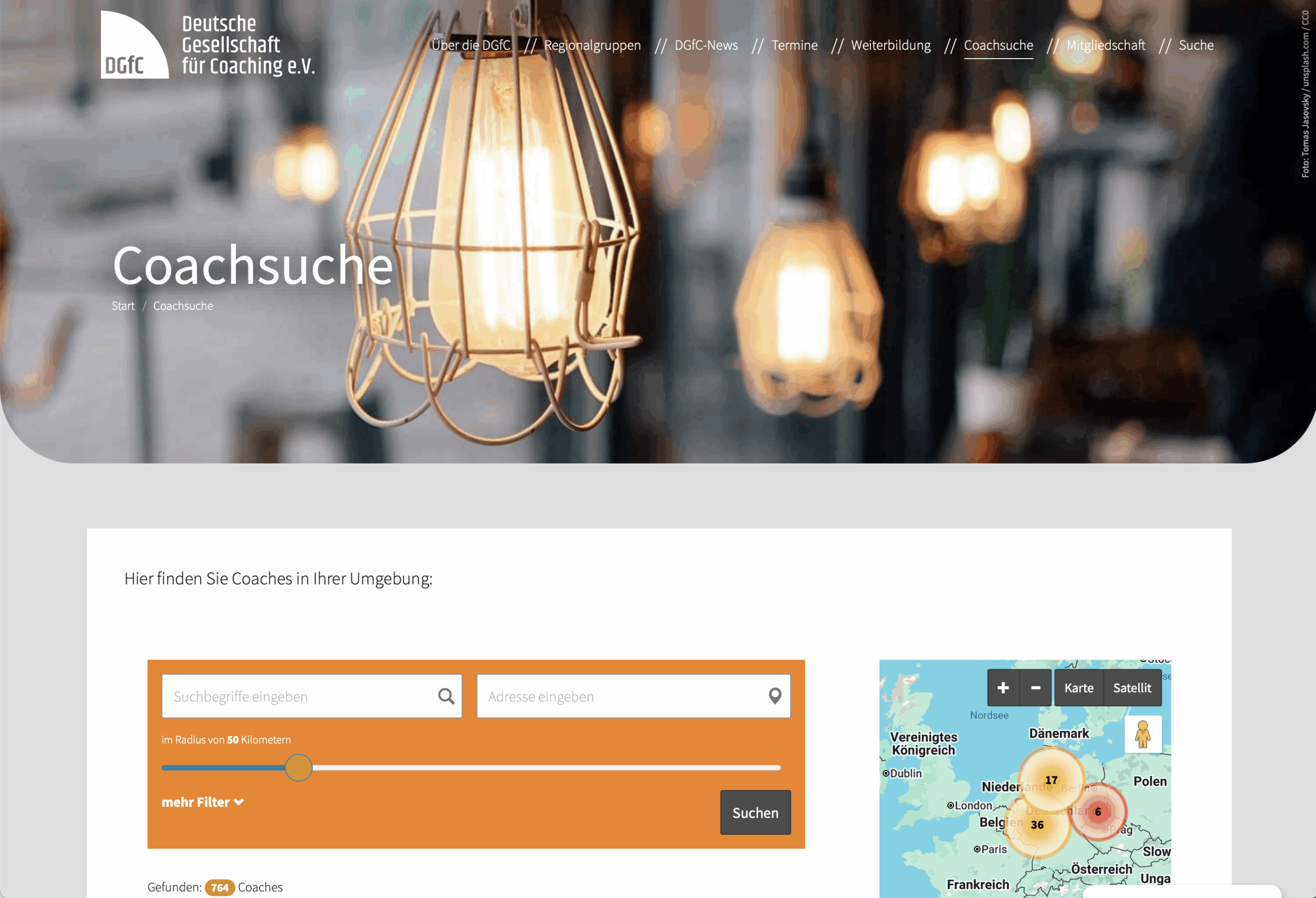 Screenshot einer Website mit dem Titel Coachsuche mit hängenden Hängelampen im Header, einer Suchleiste für die Suche nach Coaches, Filteroptionen und einem Kartenausschnitt auf der rechten Seite für standortbezogene Suchergebnisse.