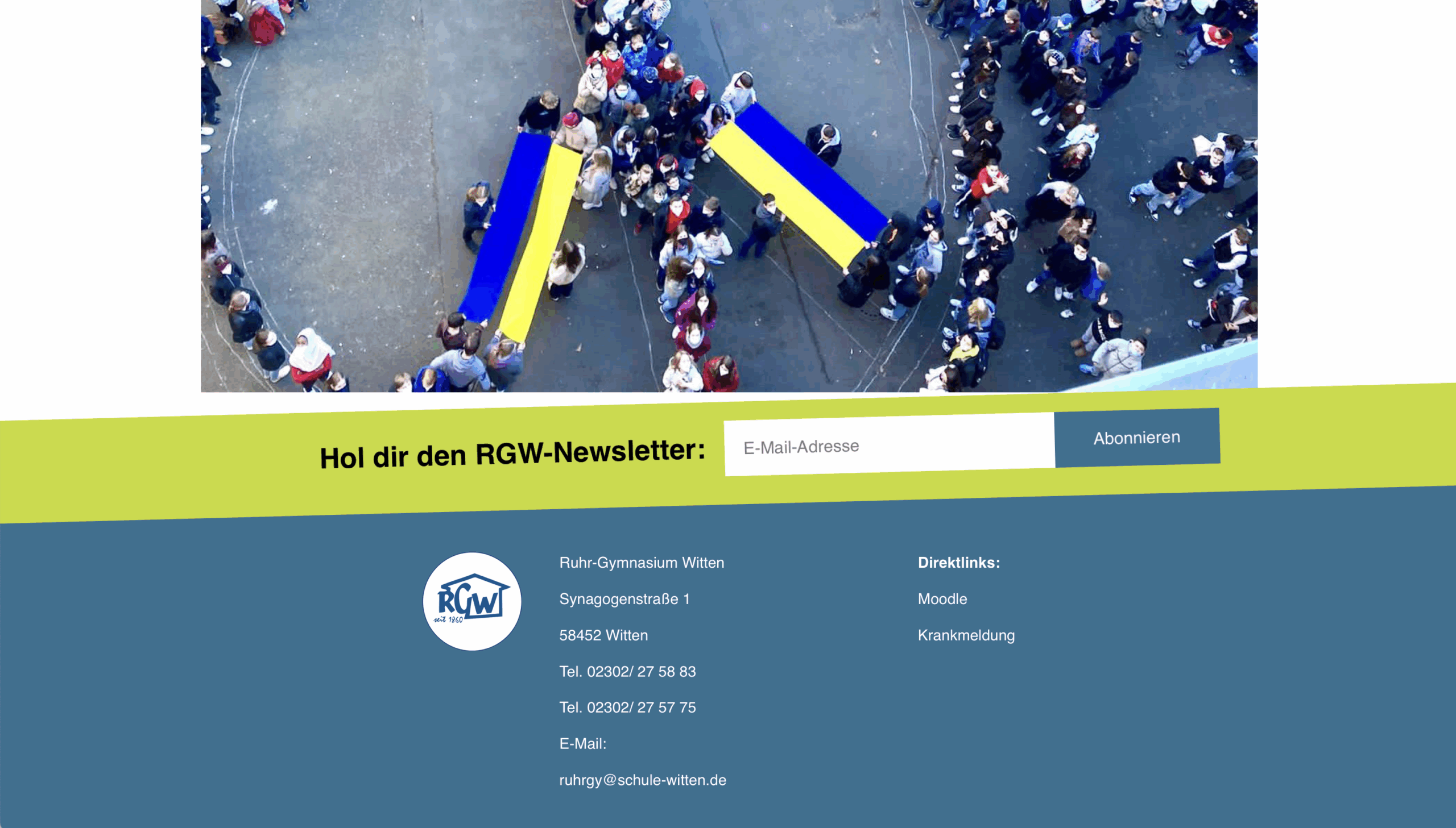 Eine Gruppe von Menschen steht in Form eines Friedenssymbols, von oben gesehen. Zwei große blaue und gelbe ukrainische Flaggen sind inmitten der Menge zu sehen.